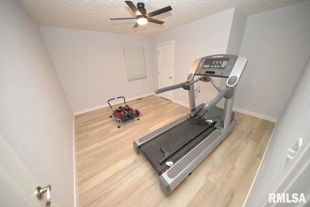 exercise area with hardwood / wood-style floors, a textured ceiling, and ceiling fan