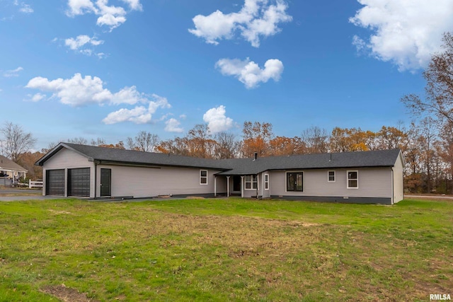 rear view of property with a yard and a garage