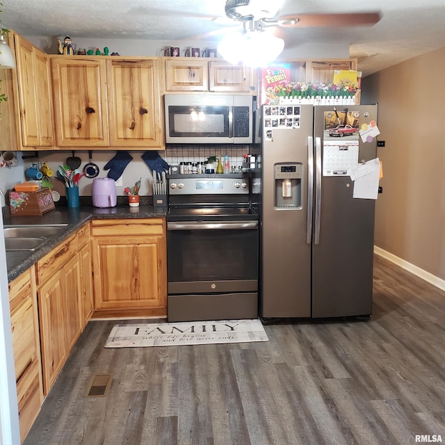 kitchen featuring decorative backsplash, dark hardwood / wood-style flooring, stainless steel appliances, and a textured ceiling