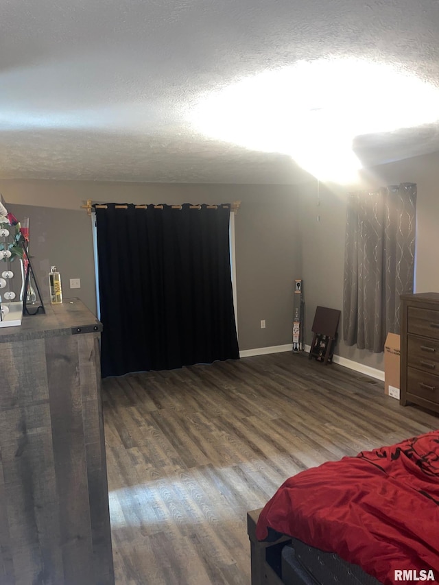 bedroom with a textured ceiling and dark wood-type flooring