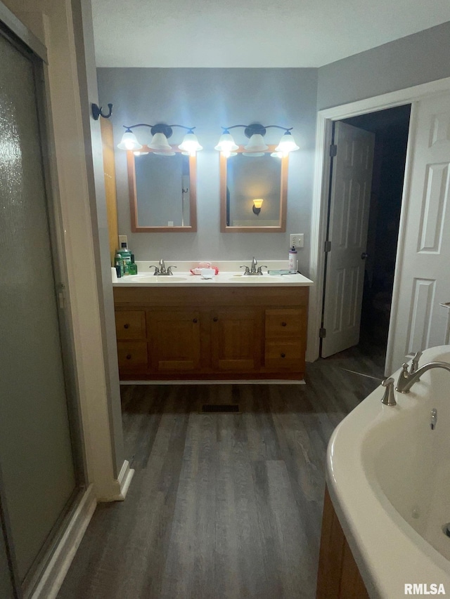 bathroom with vanity, a bath, and hardwood / wood-style flooring