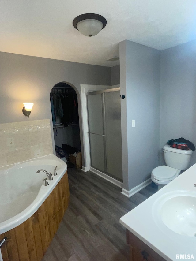 full bathroom featuring vanity, toilet, wood-type flooring, and independent shower and bath