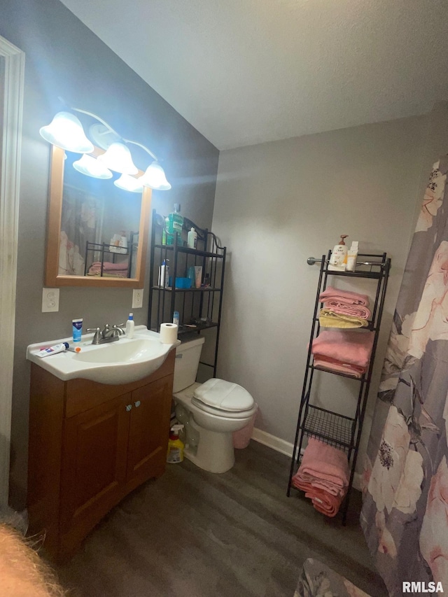 bathroom with hardwood / wood-style flooring, vanity, and toilet