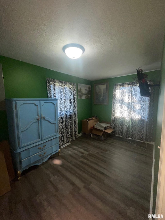 bedroom with dark hardwood / wood-style flooring and a textured ceiling