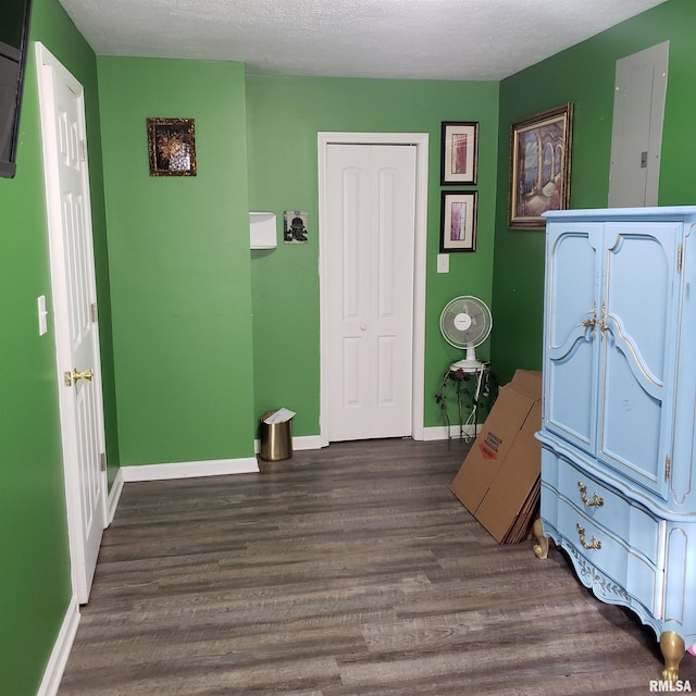 bedroom with a textured ceiling, a closet, and dark wood-type flooring