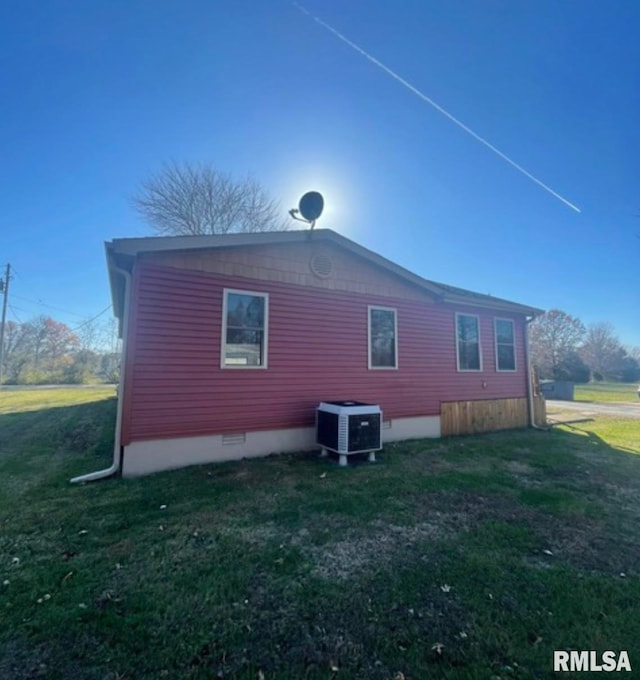 view of side of home featuring a yard and central air condition unit