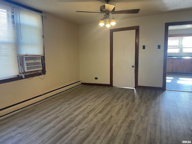 unfurnished room with ceiling fan, dark wood-type flooring, baseboard heating, cooling unit, and a textured ceiling