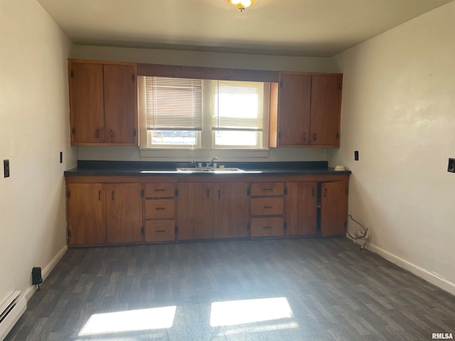 kitchen featuring baseboard heating, dark wood-type flooring, and sink