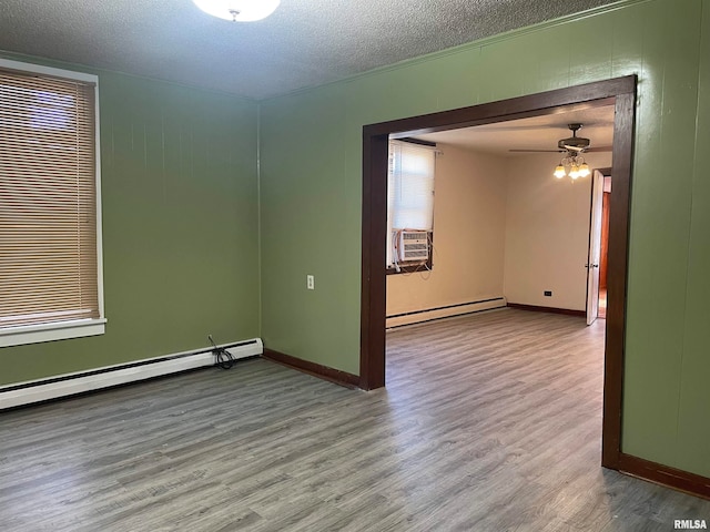 empty room with baseboard heating, ceiling fan, a textured ceiling, and hardwood / wood-style flooring