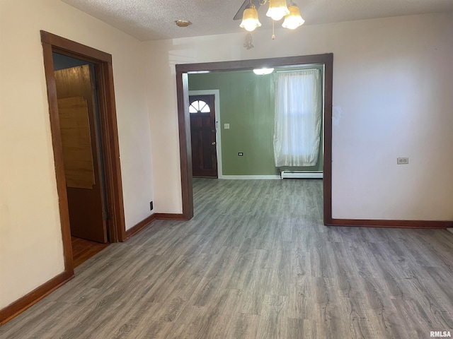 interior space with hardwood / wood-style floors, a textured ceiling, and a baseboard radiator