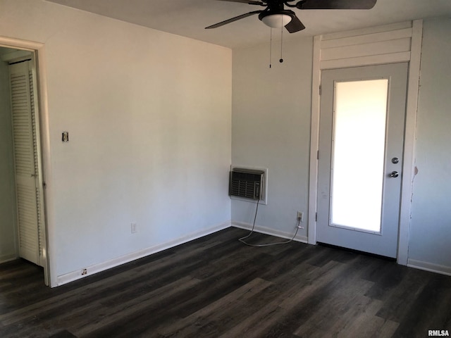 spare room with an AC wall unit, ceiling fan, and dark hardwood / wood-style floors