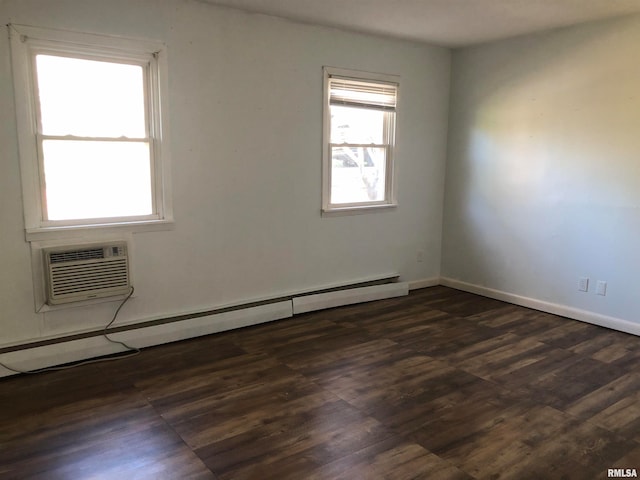 spare room with dark hardwood / wood-style floors, a wall mounted AC, and a baseboard radiator