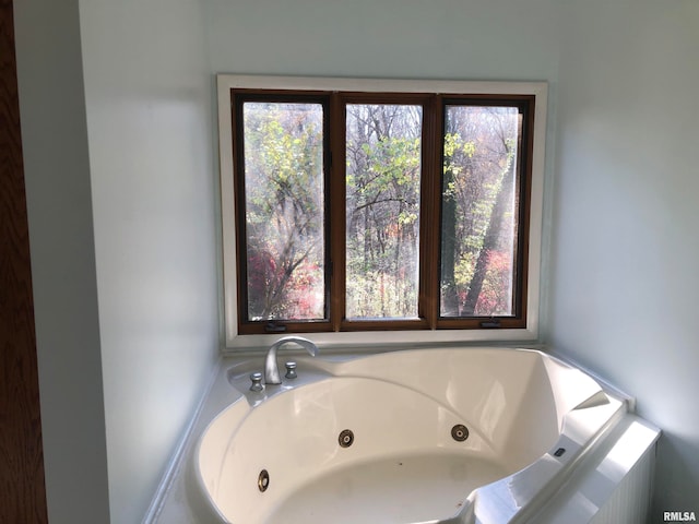 bathroom featuring tiled bath and plenty of natural light