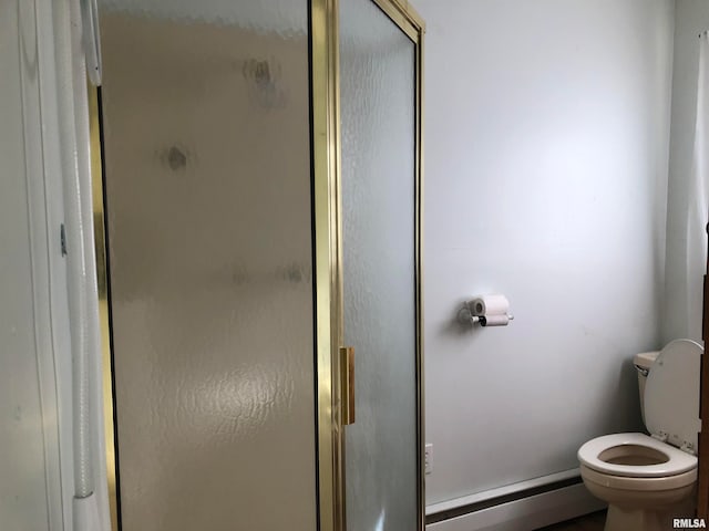 bathroom featuring toilet, an enclosed shower, and baseboard heating