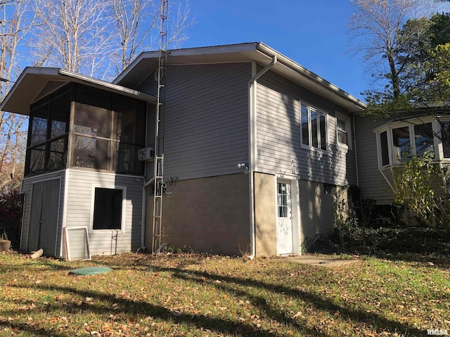 view of side of home with a lawn and a sunroom