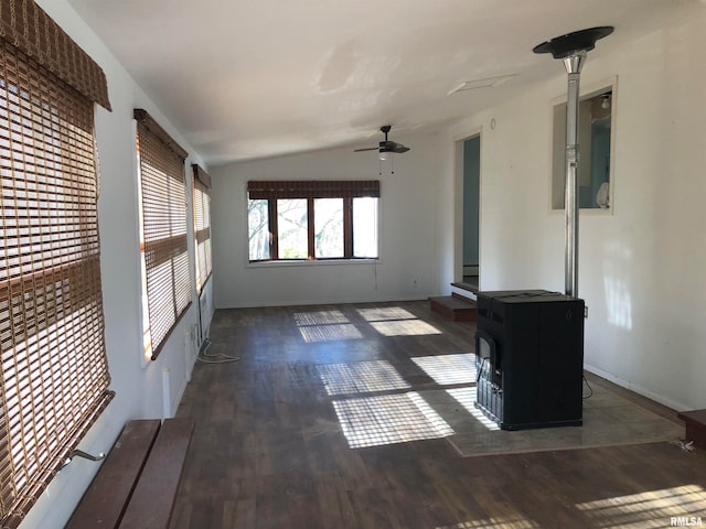 spare room with a wood stove, ceiling fan, dark wood-type flooring, and lofted ceiling