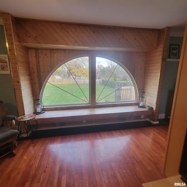 sitting room featuring wooden walls and dark hardwood / wood-style floors