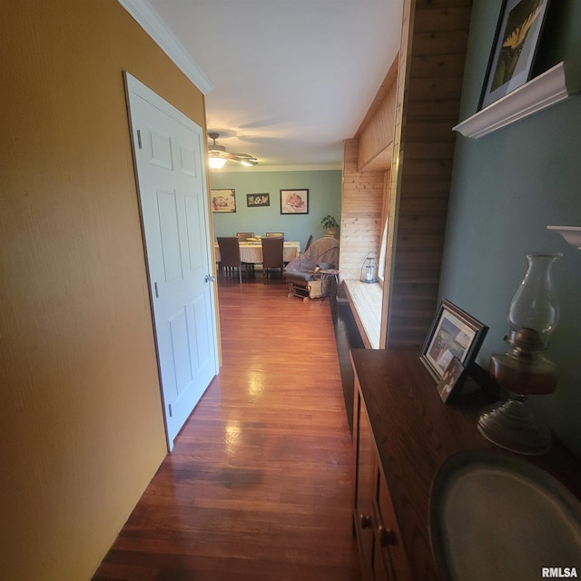 hall featuring ornamental molding and dark wood-type flooring