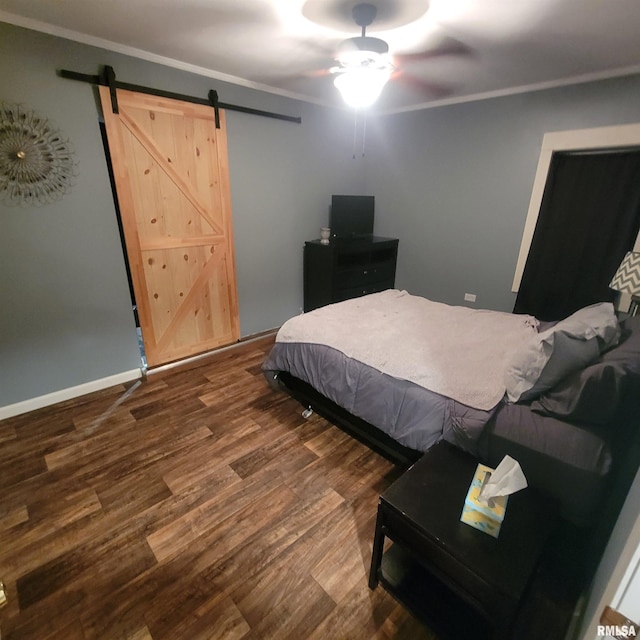 bedroom featuring a barn door, crown molding, ceiling fan, and dark wood-type flooring