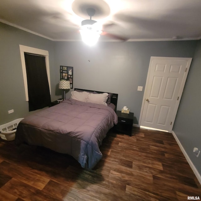 bedroom with dark hardwood / wood-style flooring and crown molding