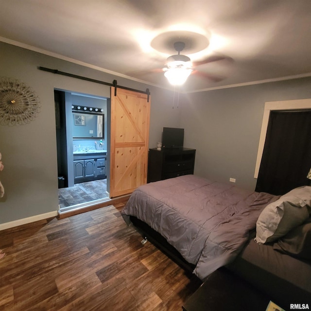 bedroom featuring connected bathroom, ceiling fan, a barn door, dark hardwood / wood-style flooring, and ornamental molding