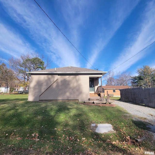 rear view of property featuring a yard