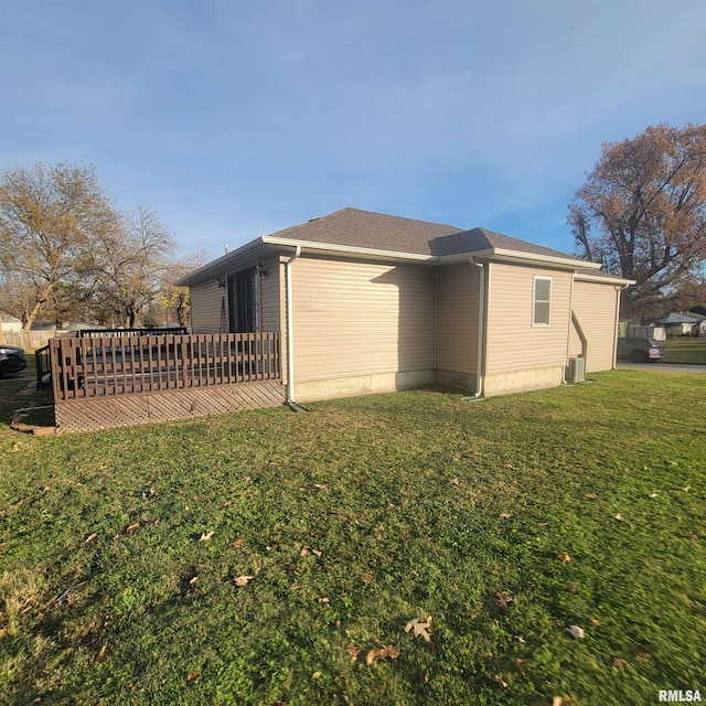 view of side of property with a lawn and a deck