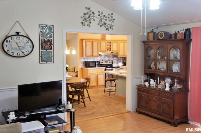 dining room featuring light hardwood / wood-style flooring and vaulted ceiling