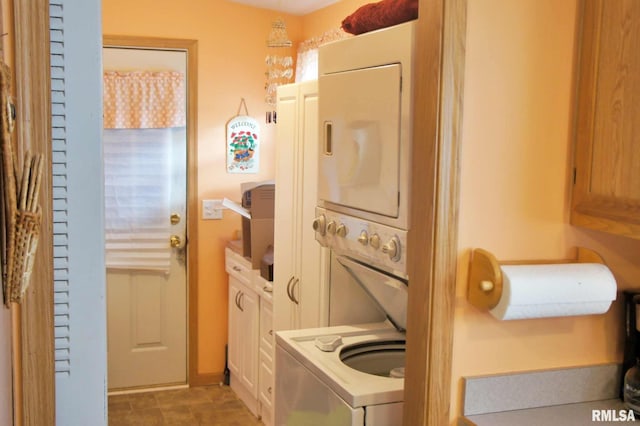 washroom featuring stacked washer and clothes dryer