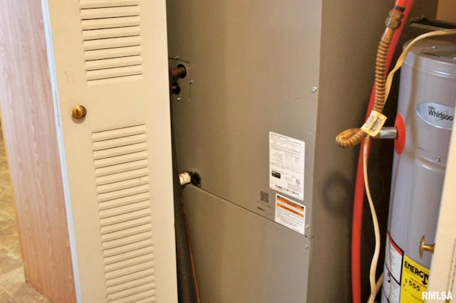 utility room featuring heating unit and water heater