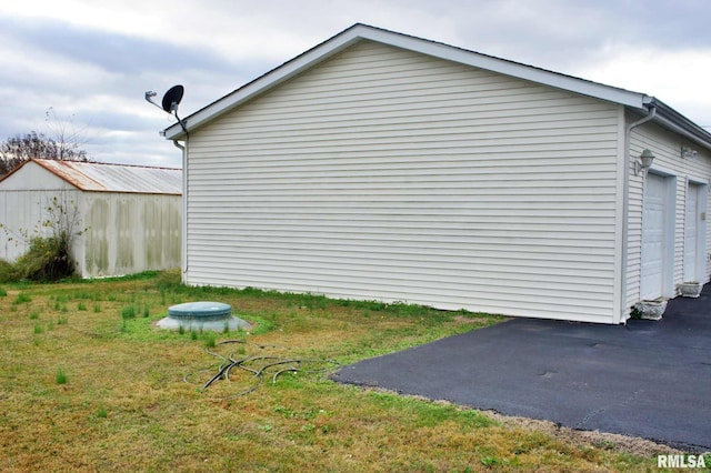 view of property exterior featuring a garage and a lawn