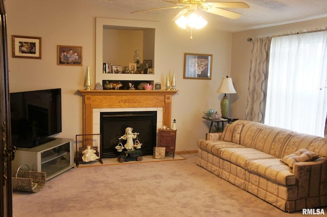 living room featuring carpet flooring, a tile fireplace, ceiling fan, and a textured ceiling