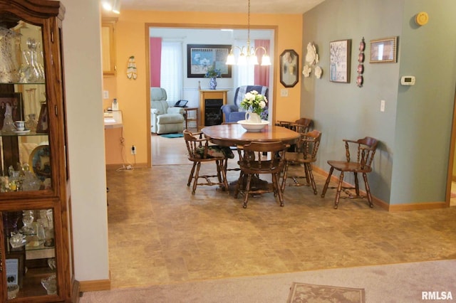 carpeted dining room featuring a notable chandelier