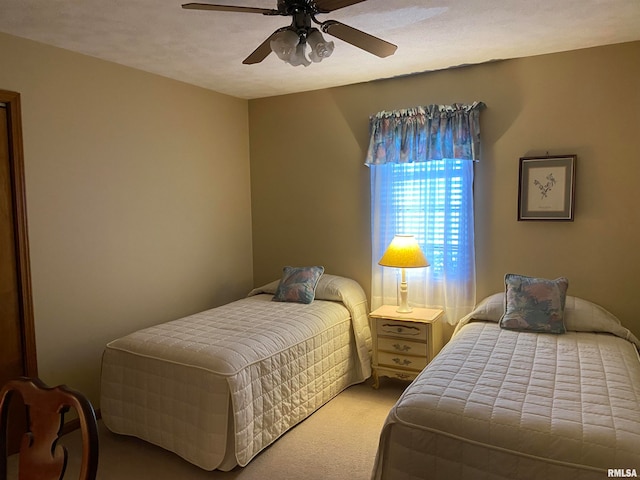 carpeted bedroom featuring ceiling fan and a textured ceiling