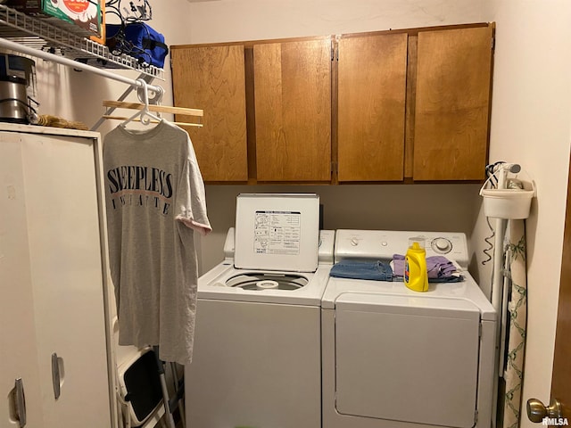 washroom featuring cabinets and washing machine and clothes dryer