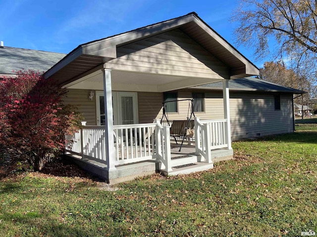 back of property featuring covered porch and a yard