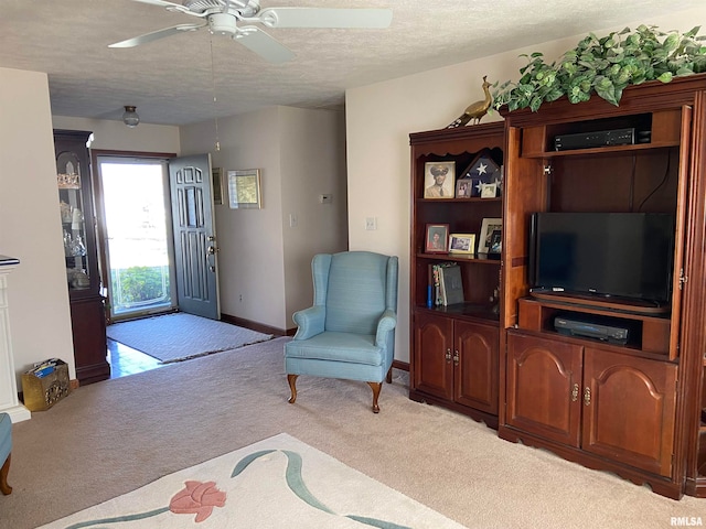 living room with light carpet, a textured ceiling, and ceiling fan