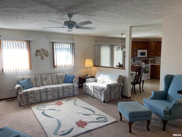 carpeted living room featuring ceiling fan with notable chandelier and a textured ceiling