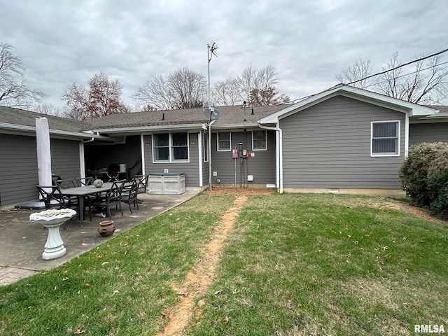 rear view of property featuring a yard and a patio area