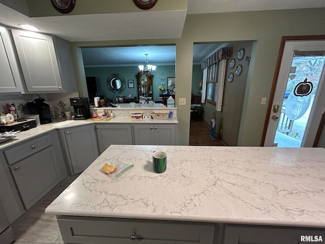 kitchen with a notable chandelier, gray cabinets, and crown molding