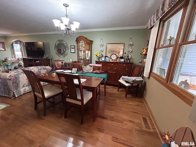 dining room featuring crown molding, hardwood / wood-style floors, and a chandelier