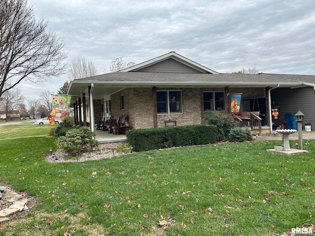 rear view of property featuring a porch and a yard