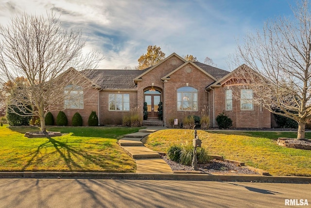 view of front of property featuring a front yard and french doors