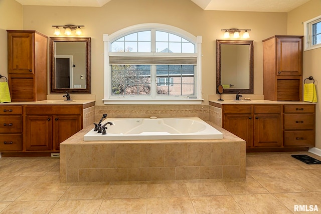 bathroom featuring vanity, tiled bath, and a wealth of natural light