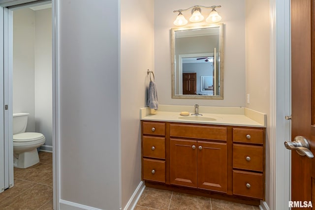 bathroom featuring tile patterned floors, vanity, ceiling fan, and toilet