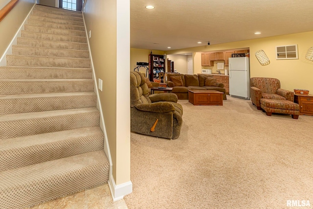 living room featuring light carpet and a textured ceiling