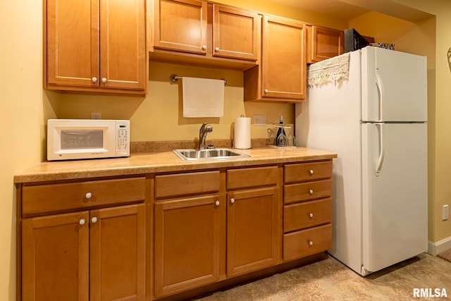 kitchen featuring white appliances and sink