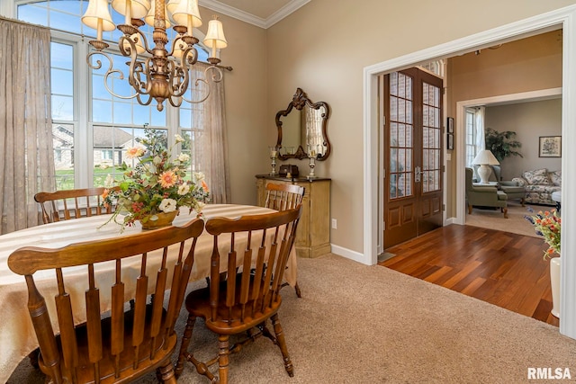 dining area featuring french doors, hardwood / wood-style flooring, a healthy amount of sunlight, and a notable chandelier