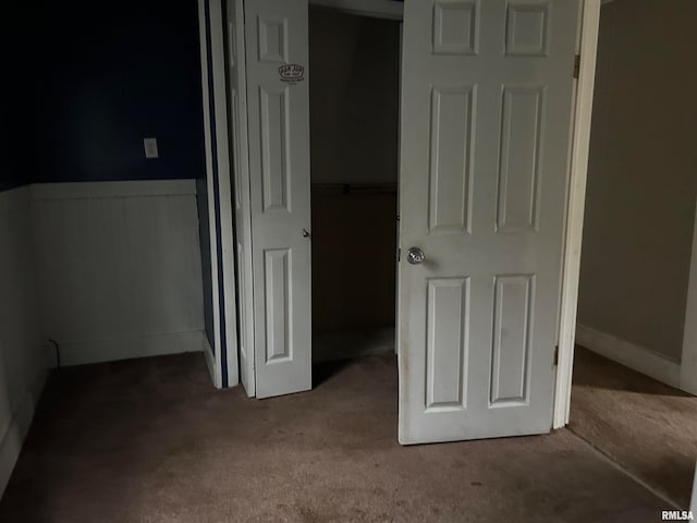 unfurnished bedroom featuring light carpet and a closet