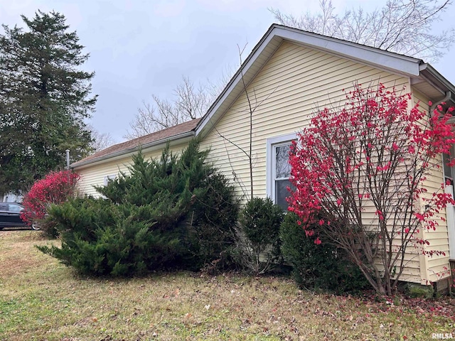 view of side of property with a lawn